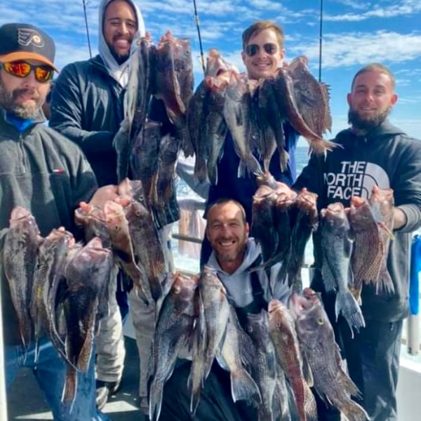 a group of people standing in front of a fish