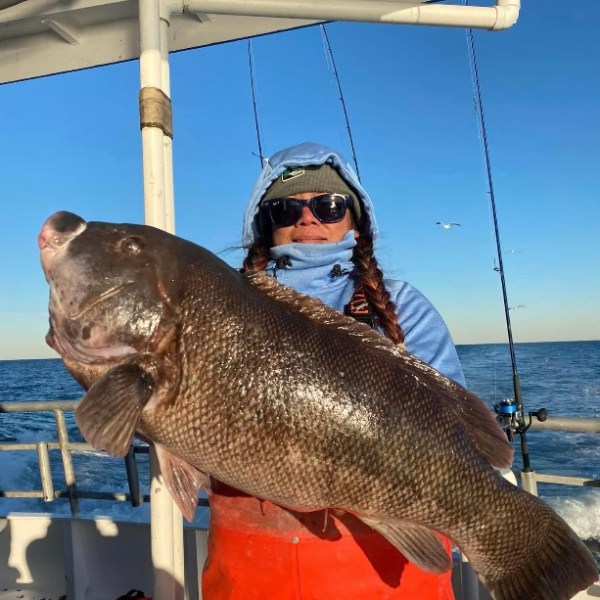 a person holding a fish on a boat