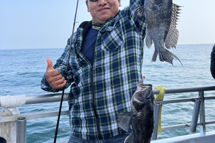 a person holding a fish on a boat in a body of water