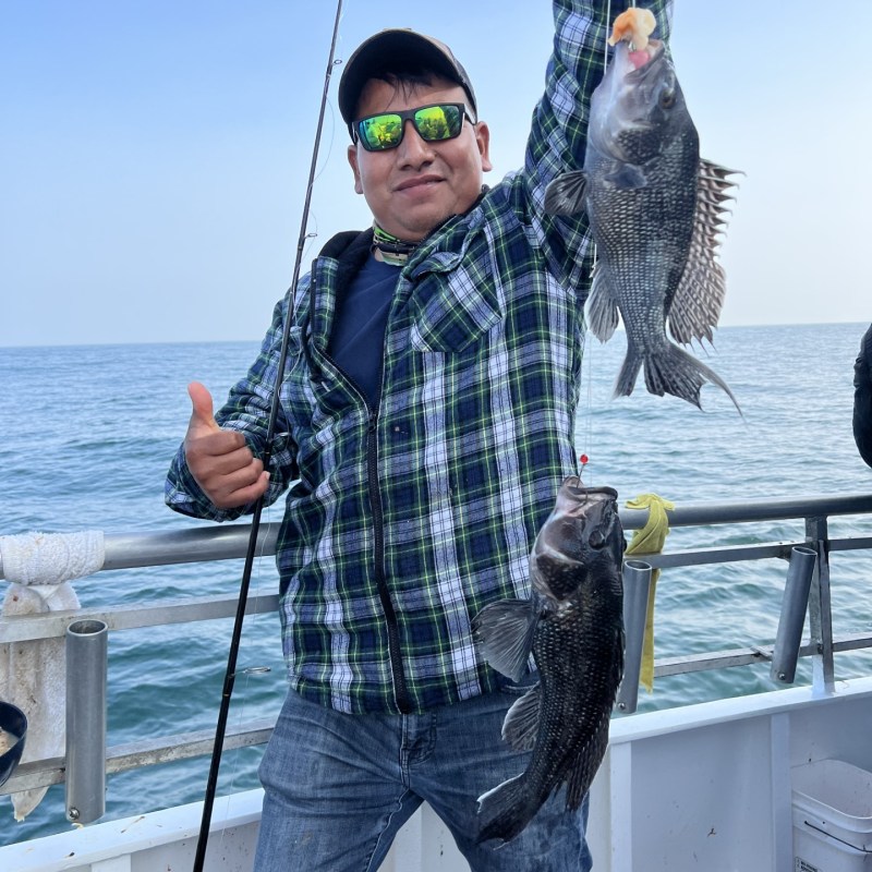 a person holding a fish on a boat in a body of water
